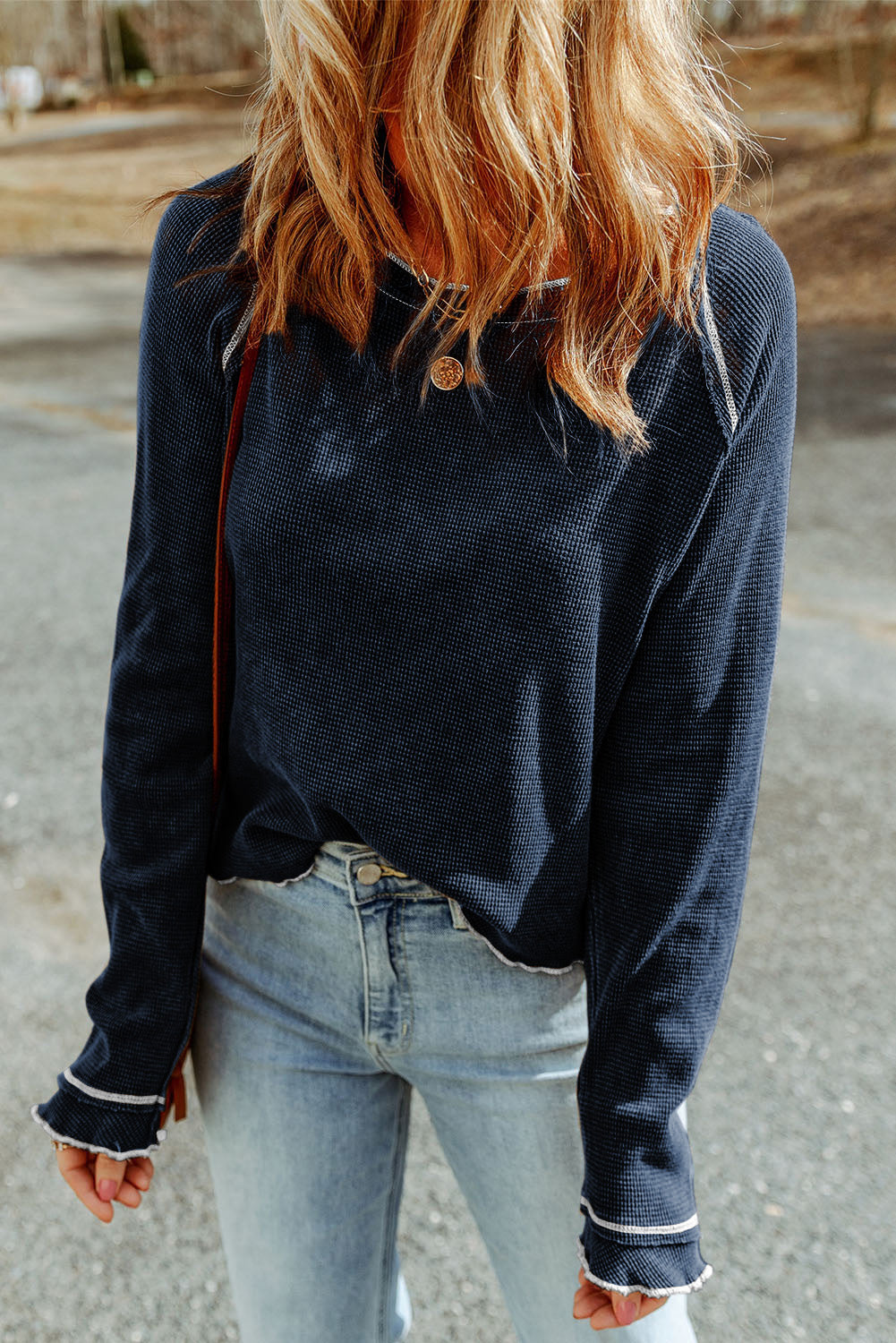 Side angle of navy blue textured knit sweater highlighting relaxed fit and stitching detail.