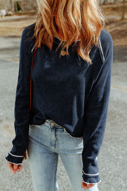 Side angle of navy blue textured knit sweater highlighting relaxed fit and stitching detail.