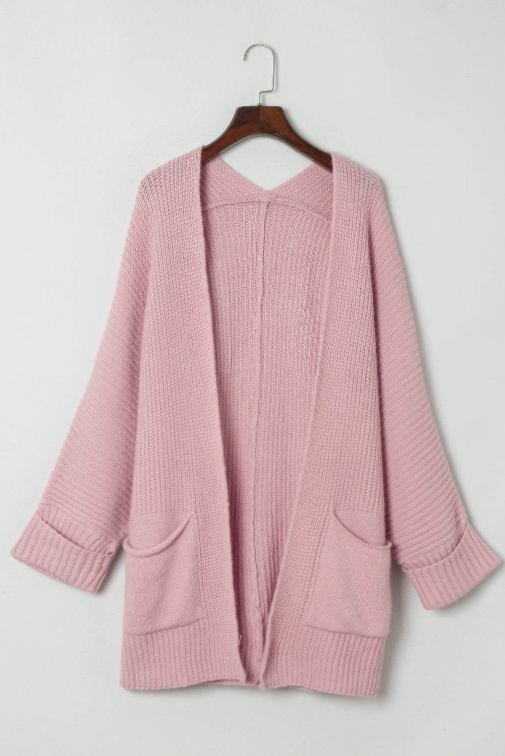 Oversized soft knit open-front cardigan displayed on hanger with patch pockets and ribbed cuffs
