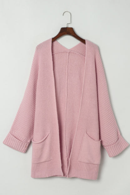Oversized soft knit open-front cardigan displayed on hanger with patch pockets and ribbed cuffs